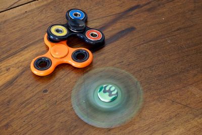 High angle view of colorful fidget spinners on wooden table