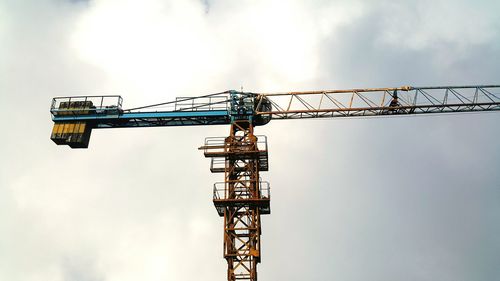 Low angle view of crane against sky