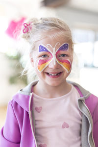 Portrait of smiling girl with painted butterfly on face