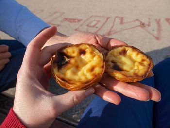 High angle view of hand holding portugees dessert  pasteis de nata de belem.