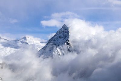 Low angle view of snowcapped mountains against sky