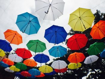 Low angle view of umbrellas hanging against sky