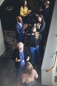 High angle view of male and female entrepreneurs discussing while standing in office