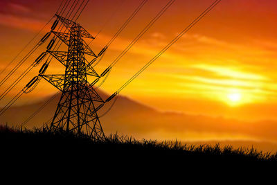 Silhouette electricity pylon on field against sky during sunset