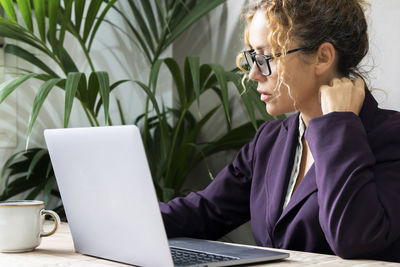 Businesswoman using laptop at table