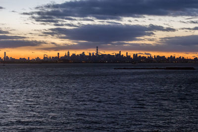 View of city at waterfront during sunset