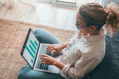 Young woman using digital tablet while sitting at home