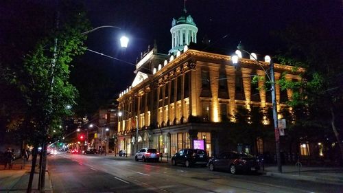 Illuminated city street and buildings at night