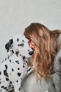 Side view of woman with dog on floor at home