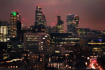 Illuminated cityscape against sky at night