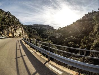 Road by bridge against sky