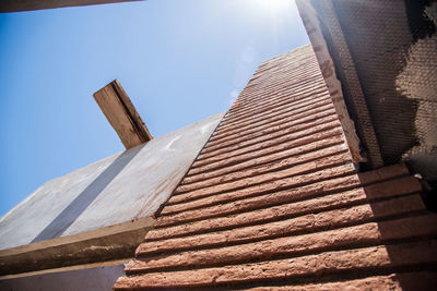 Low angle view of roof tiles against blue sky