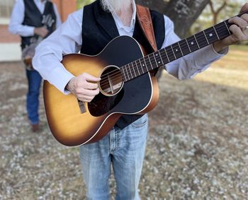 Midsection of man playing guitar