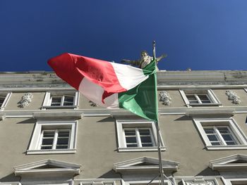 Low angle view of flag against clear blue sky