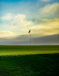 Scenic view of golf course against sky