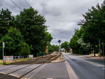 Empty road against cloudy sky