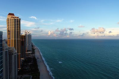 Sea by buildings against sky