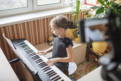 Boy playing piano at home