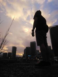 Silhouette of man with cityscape in background