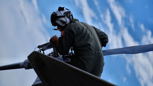 Low angle view of man working against sky