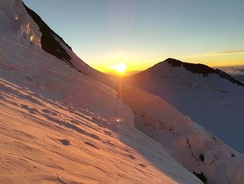 Scenic view of snowcapped mountains against sky during sunset