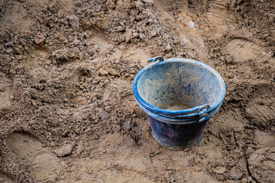 High angle view of bucket on sand floor in construction site.