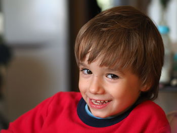 Close-up portrait of boy smiling at home