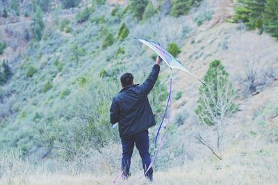 Rear view of man standing on rock