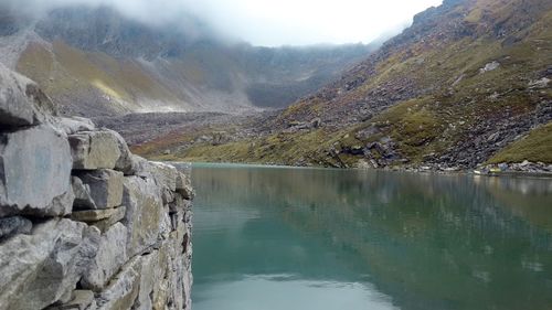 Scenic view of lake by mountains against sky