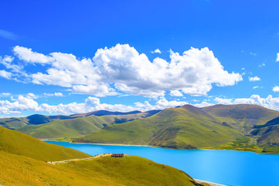 Scenic view of lake and mountains against blue sky