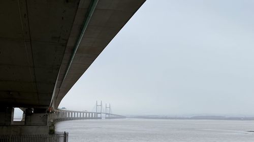 Low angle view of bridge over road against sky