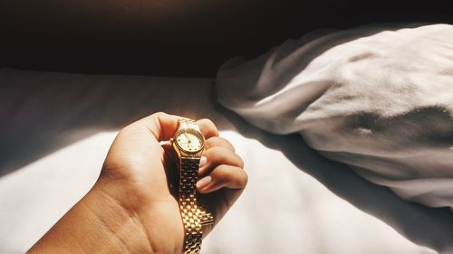 Close-up of man holding wristwatch