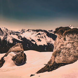 Scenic view of snowcapped mountains against sky during sunset