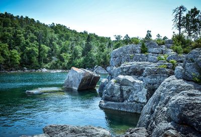 Scenic view of waterfall in forest against sky