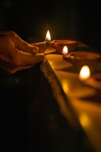 Human hand holding lit candles