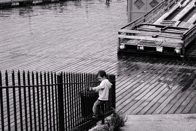 Boy playing on railing in city