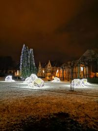 Illuminated buildings in city at night during winter