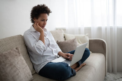 Serious african american freelancer using laptop