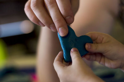 Mother and child holding heart shape clay