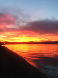 Scenic view of sea against dramatic sky during sunset