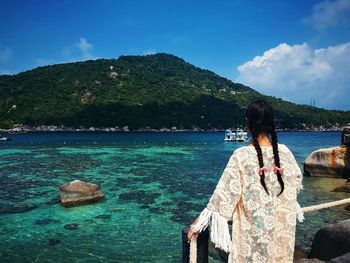 Rear view of woman looking at sea against sky