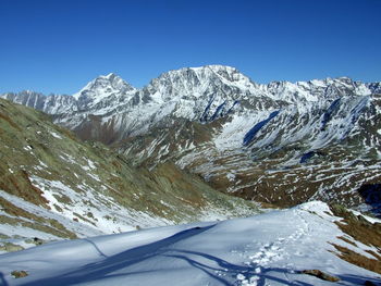 Snowcapped mountains against clear blue sky