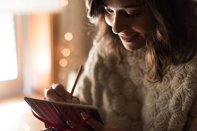 Woman looking at camera while using smart phone