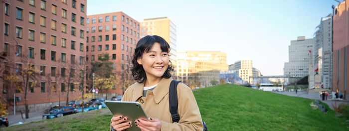 Young woman using mobile phone in city