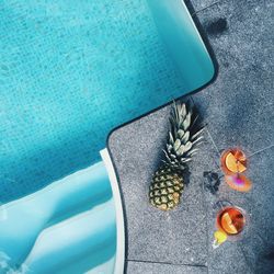 Directly above view of pineapple and drinks at poolside