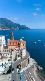 High angle view of townscape by sea against sky