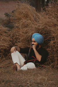 Full length of man sitting on hay