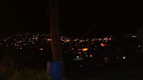 Illuminated cityscape against sky at night