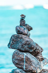 Close-up of stone stack on rock by sea against sky