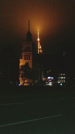 Illuminated buildings against sky at night